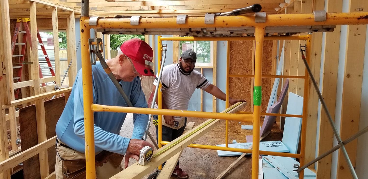 Habitat volunteer measuring a board