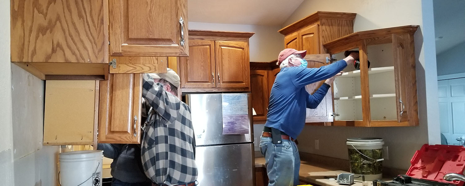Deconstruction crew removing cabinets