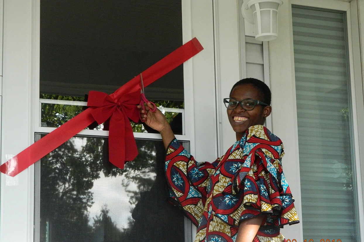 Habitat homeowner cutting ribbon of new home.