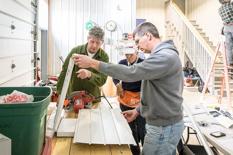 Construction staff trimming siding