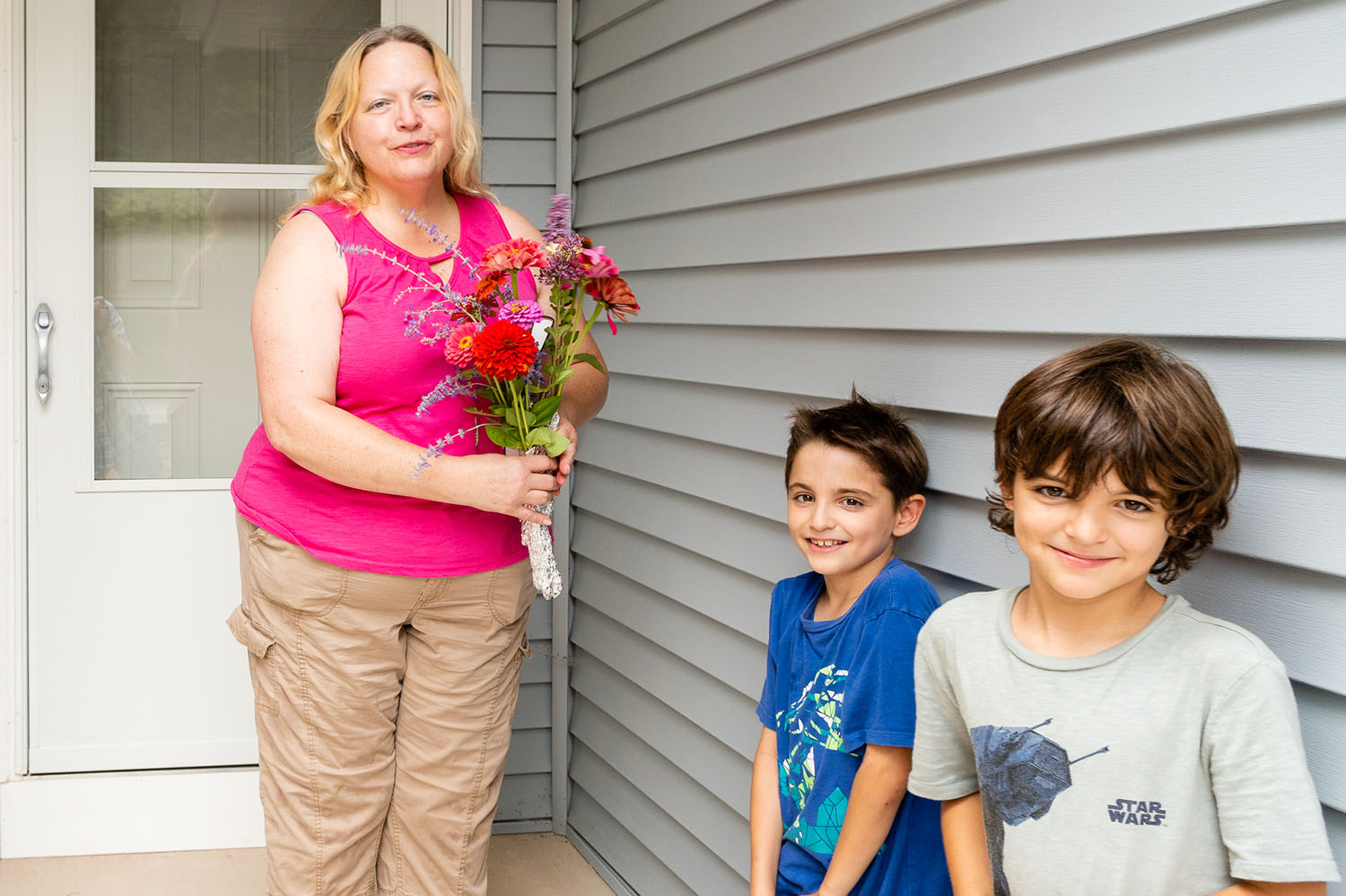 Mother with children in front of new habitat home