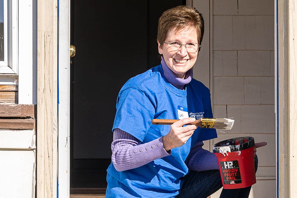 Volunteer painting door frame