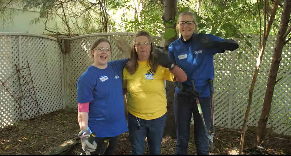 Group of volunteers cleaning back yard during Rock the Block event