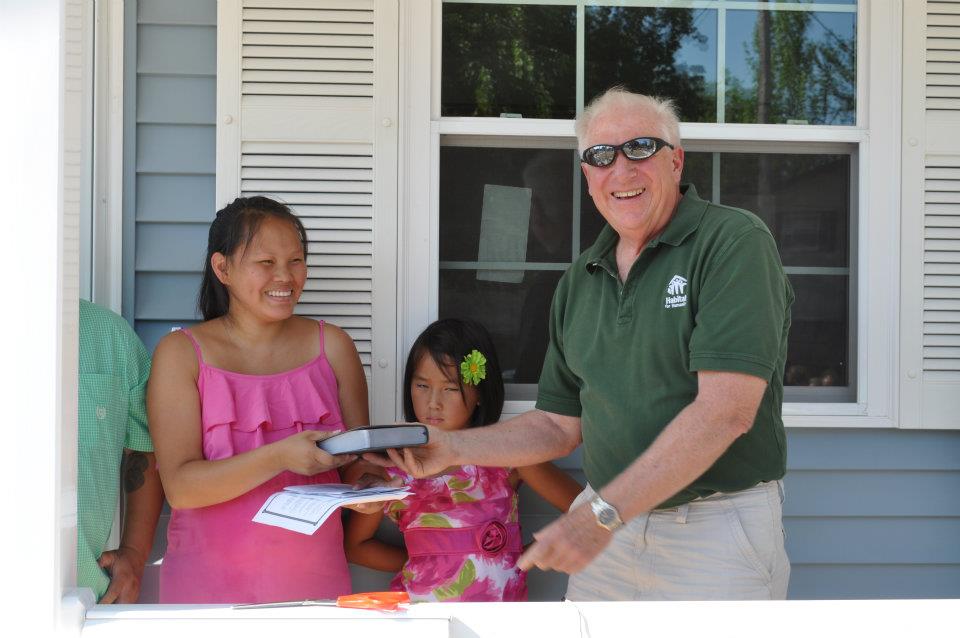 Bill handing bible to habitat homeowner