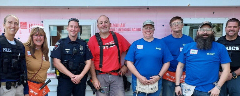 Local police posing with volunteers during rock the block