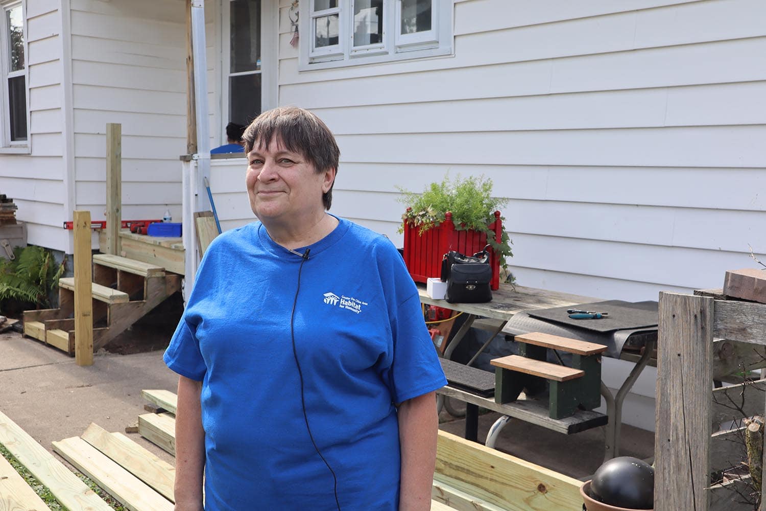 Mary Ann speaking in front of her home during repair work