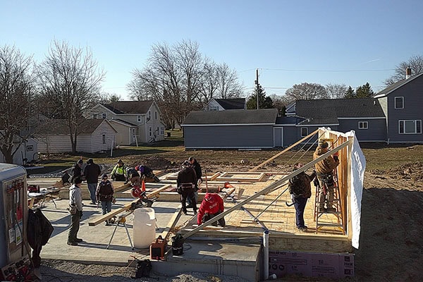 Fox Cities Habitat volunteers working together to raise a framed wall of a new home. This is the thumbnail image to play a video of volunteers raising walls